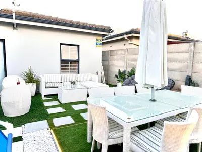 a patio with white furniture and a table and chairs at Luxury 2bedrooms house in Cape Town