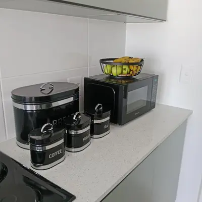 a kitchen counter with a toaster oven and a microwave at The Cozy Nest in Cape Town