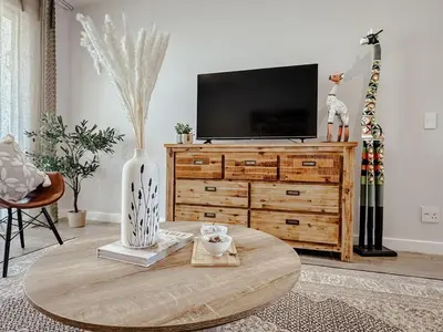 a living room with a tv and a wooden table at Le Bourgette 28 Misty Wink in Franschhoek