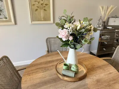 a vase of flowers sitting on a wooden table at Le Bourgette 28 Misty Wink in Franschhoek