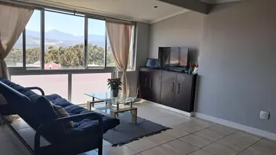 a living room with a couch and a large window at Gordon's bay - Sea view apartment in Cape Town