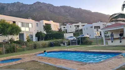 a person jumping into a swimming pool in a house at Gordon's bay - Sea view apartment in Cape Town