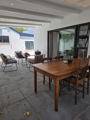 a wooden table and chairs on a patio at Zonnekus Guesthouse in Cape Town