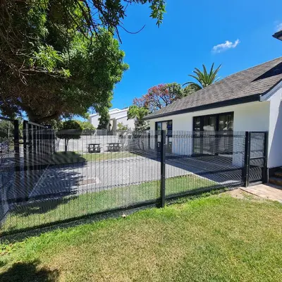 a fence in front of a house at Zonnekus Guesthouse in Cape Town