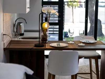 a table with two glasses and a vase with flowers at Zonnekus Guesthouse in Cape Town