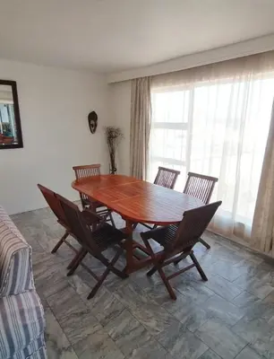 a wooden table and chairs in a living room at Lifehouse in Hermanus