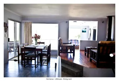 a dining room with a table and chairs and a room with a window at Lifehouse in Hermanus