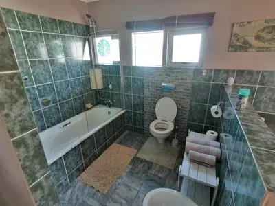 a bathroom with a toilet and a tub and a sink at Lifehouse in Hermanus