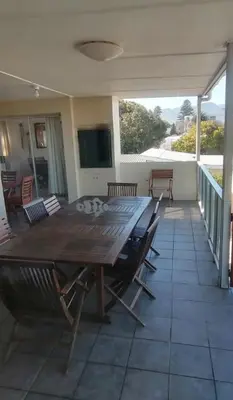 a large wooden table and chairs on a patio at Lifehouse in Hermanus
