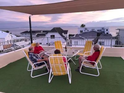 a group of people sitting in chairs on a balcony at Lifehouse in Hermanus