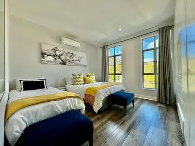 a bedroom with two beds and a window at Le Bourgette - Close to Town With Great Views in Franschhoek