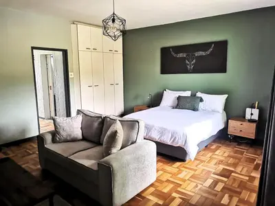 a bedroom with a bed and a couch at Sunny Mountain View in Stellenbosch