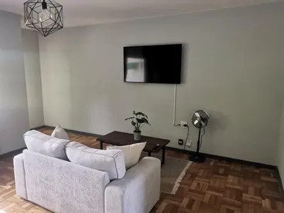 a living room with a couch and a flat screen tv at Sunny Mountain View in Stellenbosch