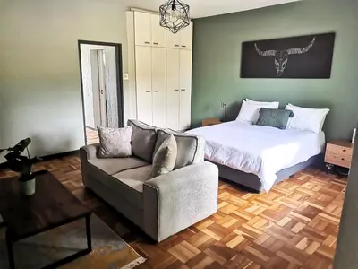 a bedroom with a bed and a couch at Sunny Mountain View in Stellenbosch
