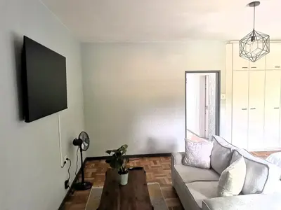 a living room with a couch and a table at Sunny Mountain View in Stellenbosch