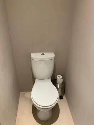 a bathroom with a white toilet in a corner at Johannies Home at Panorama Hospital in Cape Town