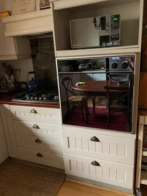 a kitchen with a table and a microwave at Johannies Home at Panorama Hospital in Cape Town