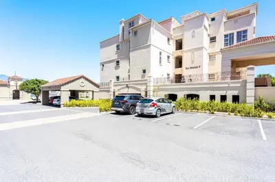 a building with two cars parked in a parking lot at Villa Italia 933 by CTHA in Cape Town