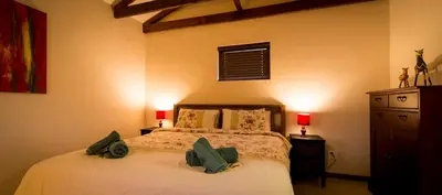 a bedroom with a bed with two green pillows on it at TreeTop Apartment Cape Town in Cape Town