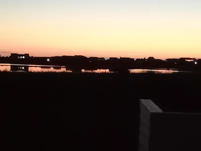a sunset over a city with a body of water at Two Lakes in Bettyʼs Bay