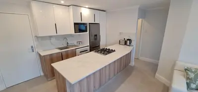 a kitchen with white counters and a counter top at 4 sleeper Lamsyh Apartment in Cape Town