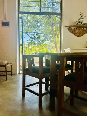 a dining room with a table and chairs and a window at Stellenbosch Farm Studio Apartment in Penhill
