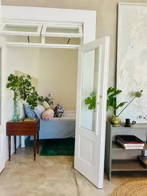 a room with a bed and a mirror and a door at Stellenbosch Farm Studio Apartment in Penhill
