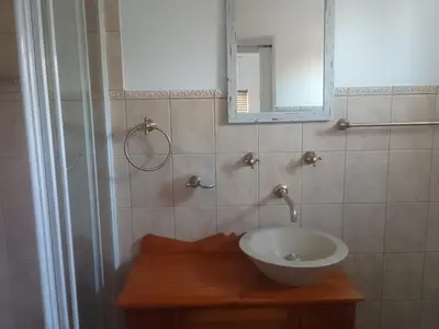 a bathroom with a bowl sink and a mirror at MBCholidayhouse in Cape Town