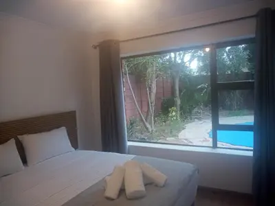 a bedroom with a bed and a large window at MBCholidayhouse in Cape Town