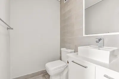 a bathroom with a toilet and a sink and a mirror at Waters Edge Luxury Apartment Century City in Cape Town