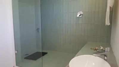 a bathroom with a glass shower with a toilet at SeaScape Silversands in Bettyʼs Bay