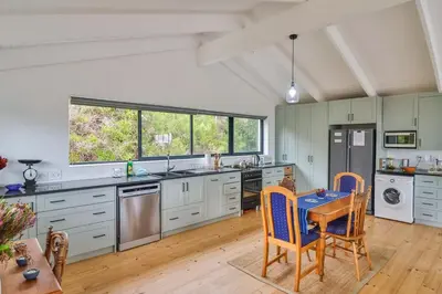 a large kitchen with a table and chairs in it at SeaScape Silversands in Bettyʼs Bay