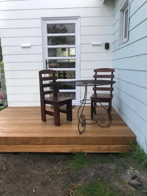 two chairs and a table on a wooden deck at Bettys Bay Breakaway in Bettyʼs Bay