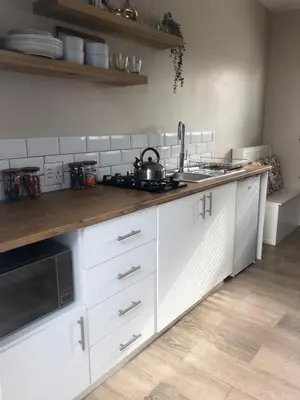 a kitchen with white cabinets and a stove top oven at Bettys Bay Breakaway in Bettyʼs Bay