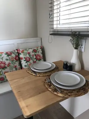two plates on a wooden table in a room at Bettys Bay Breakaway in Bettyʼs Bay
