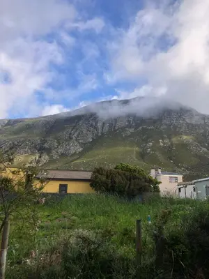a mountain in the distance with a house in the foreground at Bettys Bay Breakaway in Bettyʼs Bay