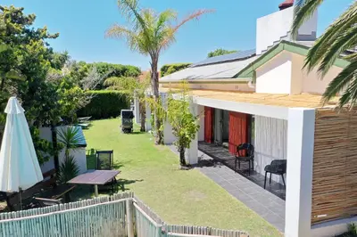 a garden with a picnic table and a umbrella at 2stay Apartment Protea - Cape Town Bloubergstrand in Cape Town