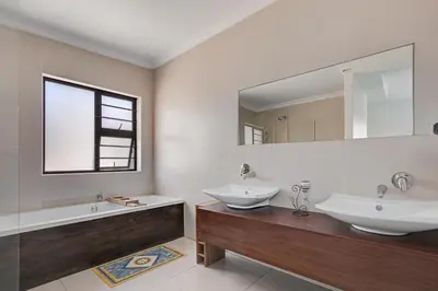 a bathroom with two sinks and a tub and a mirror at Spacious Room with Balcony, Mountain Views, Modern Bathroom Tub and Shower and WiFi and Pool view in Cape Town