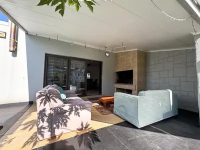 a living room with a couch and a tv at Spacious Room with Balcony, Mountain Views, Modern Bathroom Tub and Shower and WiFi and Pool view in Cape Town