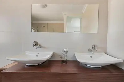 a bathroom with two sinks and a mirror at Spacious Room with Balcony, Mountain Views, Modern Bathroom Tub and Shower and WiFi and Pool view in Cape Town