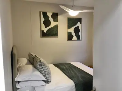 a bedroom with a bed and two pictures on the wall at Beachfront Apartment with Amazing Views on Kite Surfing Beach in Cape Town