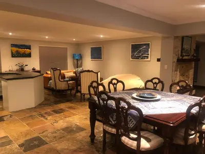 a living room with a dining table and a kitchen at 82 on Second family stay in Kleinmond