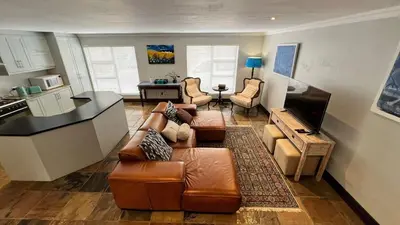 a living room with a couch and a kitchen at 82 on Second family stay in Kleinmond