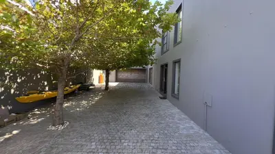 a cobblestone alley with a building and a tree at 82 on Second family stay in Kleinmond
