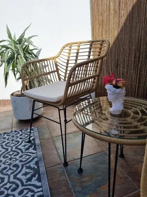 a patio with two chairs and a table with a vase of flowers at Featherbed in Hermanus