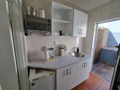 a small kitchen with a sink and a microwave at Featherbed in Hermanus