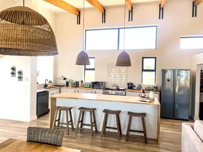 a kitchen with a large island with bar stools at 155 Hangklip self catering in Pringle Bay