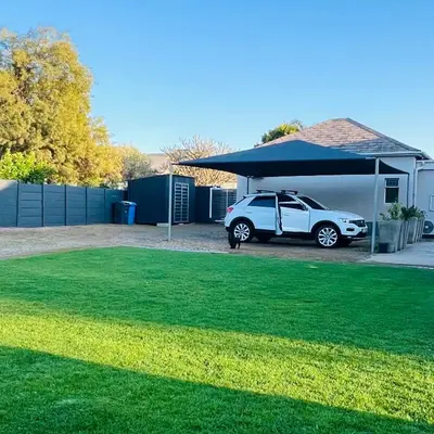 a white car parked under a blue garage at Spacious Stays Residence in Paarl