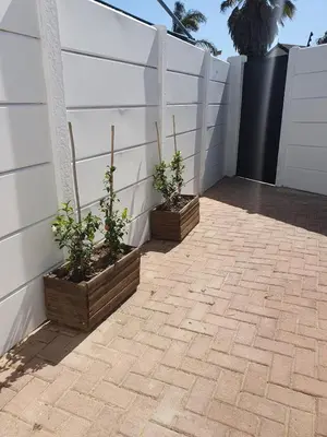 two potted plants sitting next to a white fence at Lynwood Place in Cape Town