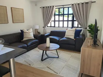 a living room with a couch and a table at Lynwood Place in Cape Town